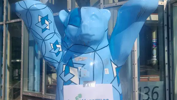 Une affichette de l'Open Hardware Summit 2026 sur une statue d'ours berlinois.