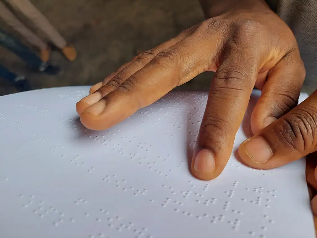 Some fingers reading Braille on paper